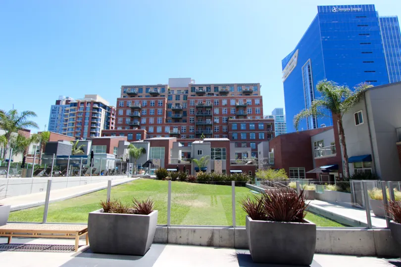 Bright sunny day over looking a large grass lawn and pool side chairs.