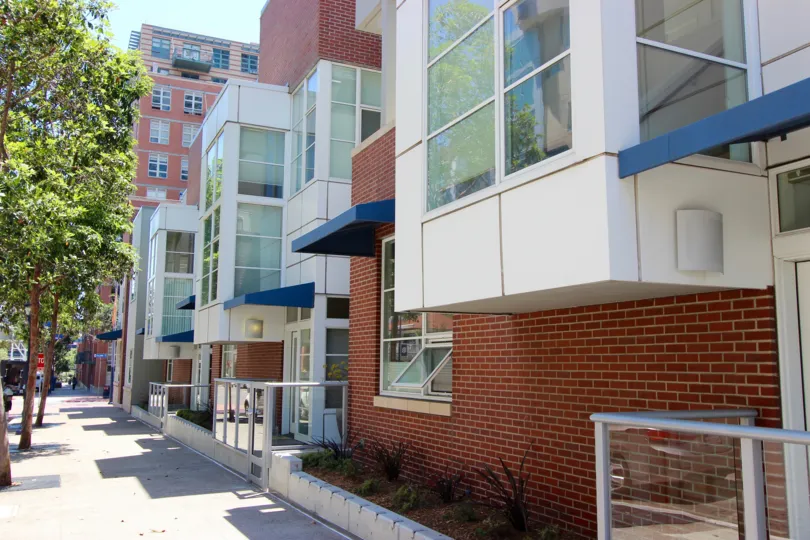 A sunny day in the area of The Mark, condos, windows, tree, blue awning, entrance