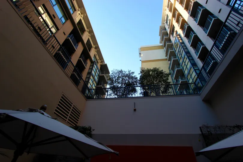 The view upward from a courtyard with umbrellas at Trellis in downtown San Diego, CA