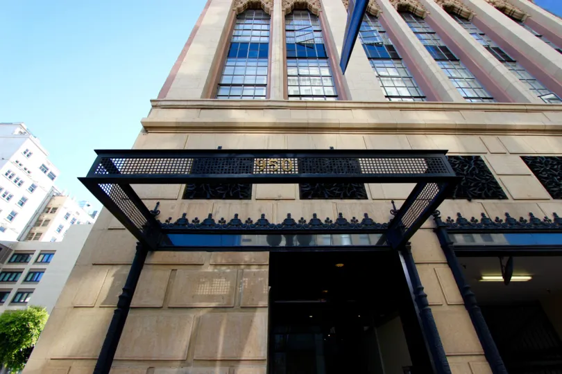 An exterior view of the Union Square building from the street showing black wrought ironwork and multi-story windows on a clear day.