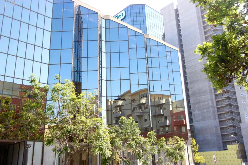 The mirrored windows of the Village Walk building reflecting the San Diego skyline.