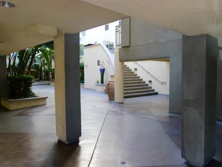 Inside parking view near stairs decorated with plants and trees in Village Walk