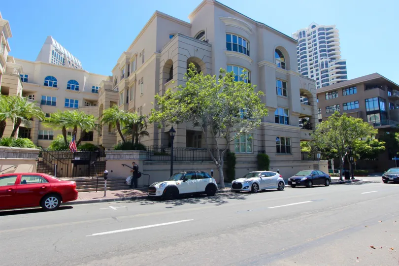 A sweeping view of the exterior of the Watermark building from across the street and part of the San Diego skyline.