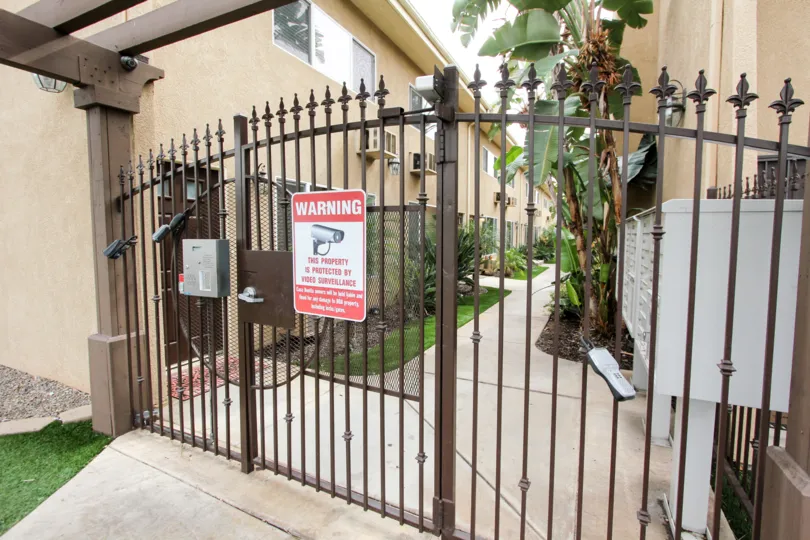 A photograph of a warning sign on a security gate in El Cajon California