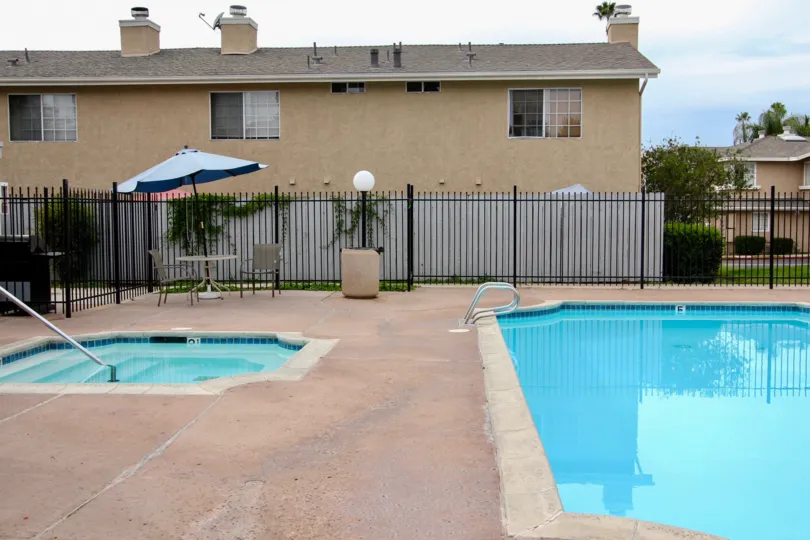 VERY BEAUTIFUL HOUSE. IN FRONT OF IT THERE ARE FOUR SMALL TREES. AND THERE IS A ROAD, VERY CLEAN. AND THERE IS A POOL.