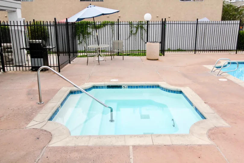 VERY BEAUTIFUL HOUSE. IN FRONT OF IT THERE ARE FOUR SMALL TREES. AND THERE IS A ROAD, VERY CLEAN. AND THERE IS A POOL.