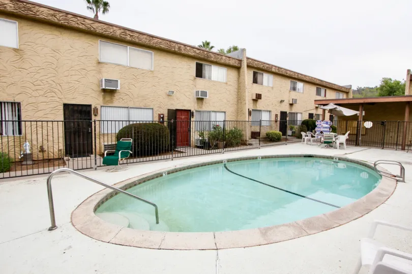 VERY BEAUTIFUL HOUSE. IN FRONT OF IT THERE ARE FOUR SMALL TREES. AND THERE IS A ROAD, VERY CLEAN. AND THERE IS A POOL.
