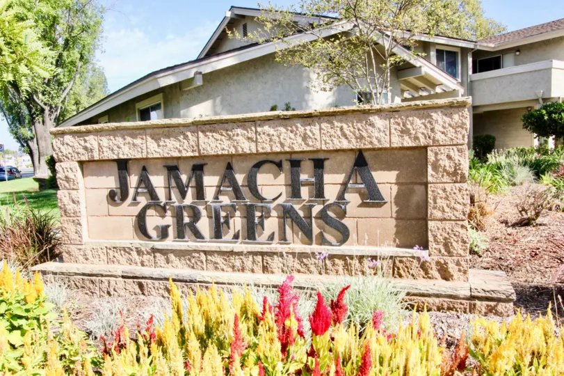 A view of Jamacha Greens Apartments Sign in El Cajon, California on a clear sunny day.