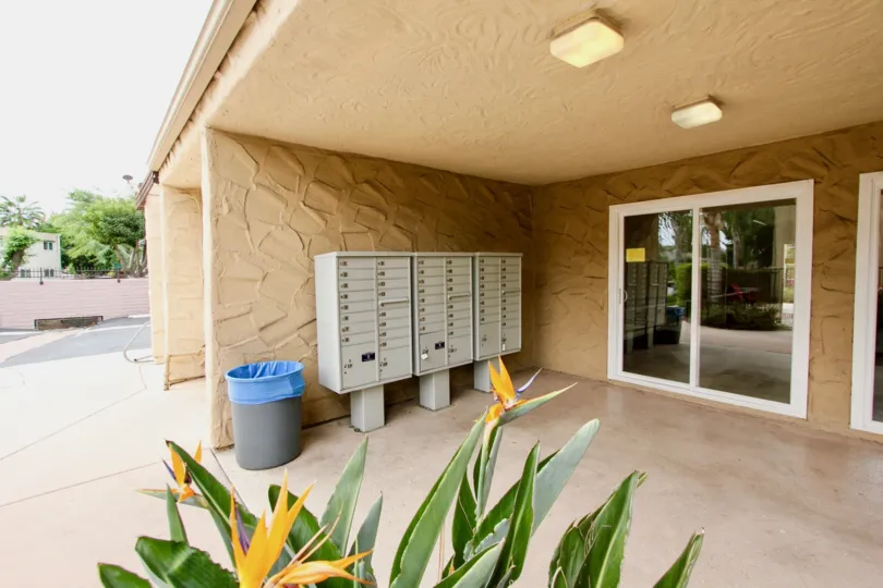 Front of beige building with post office boxes and a sliding glass door