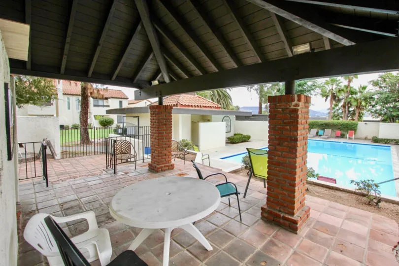VERY BEAUTIFUL HOUSE. IN FRONT OF IT THERE ARE FOUR SMALL TREES. AND THERE IS A ROAD, VERY CLEAN. AND THERE IS A POOL.