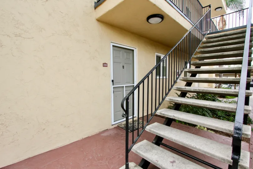Front porch of a unit in the Madison Ave Condos community, with a palm tree in the background