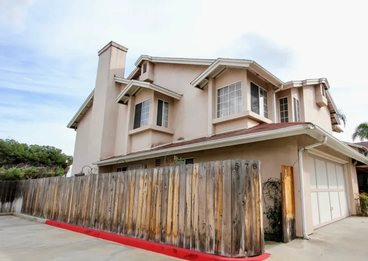 Light pink house with brown wooden fence in Magnolia Ranch, located in El Cajon, California.