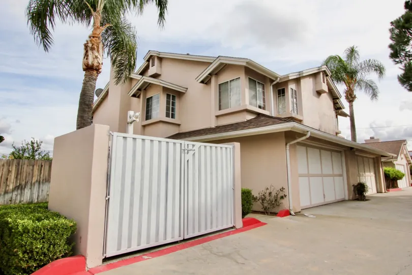 A large tan house with palm trees on an overcast day in Magnolia Ranch, a neighborhood in El Cajon, California