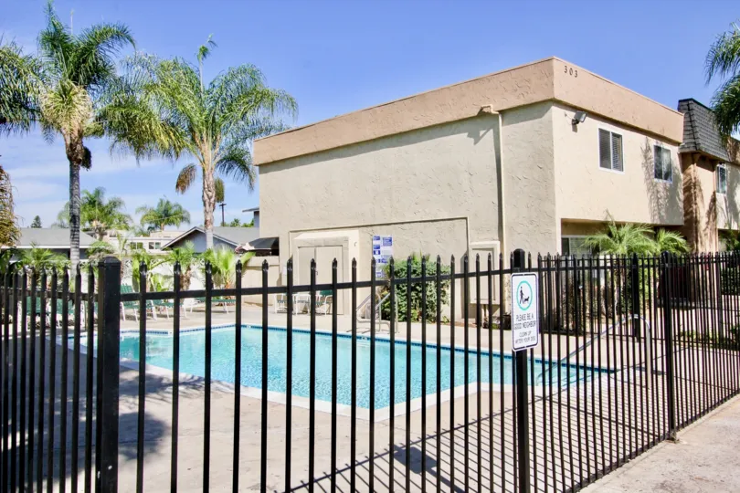VERY BEAUTIFUL HOUSE. IN FRONT OF IT THERE ARE FOUR SMALL TREES. AND THERE IS A ROAD, VERY CLEAN. AND THERE IS A POOL.