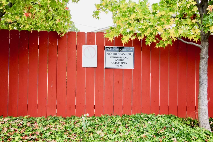 Red wooden fence with trees at Oak Creek Glen in El Cajon California