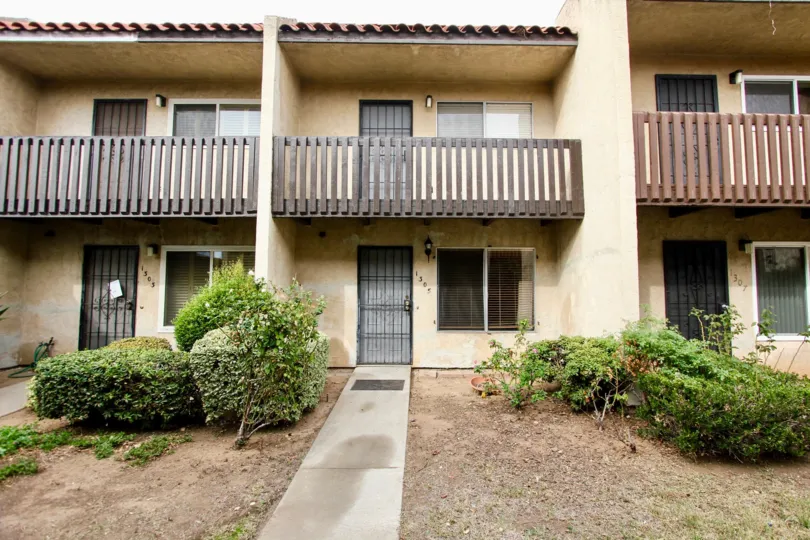 Condo or apartment rear with patio and no grass and bushes
