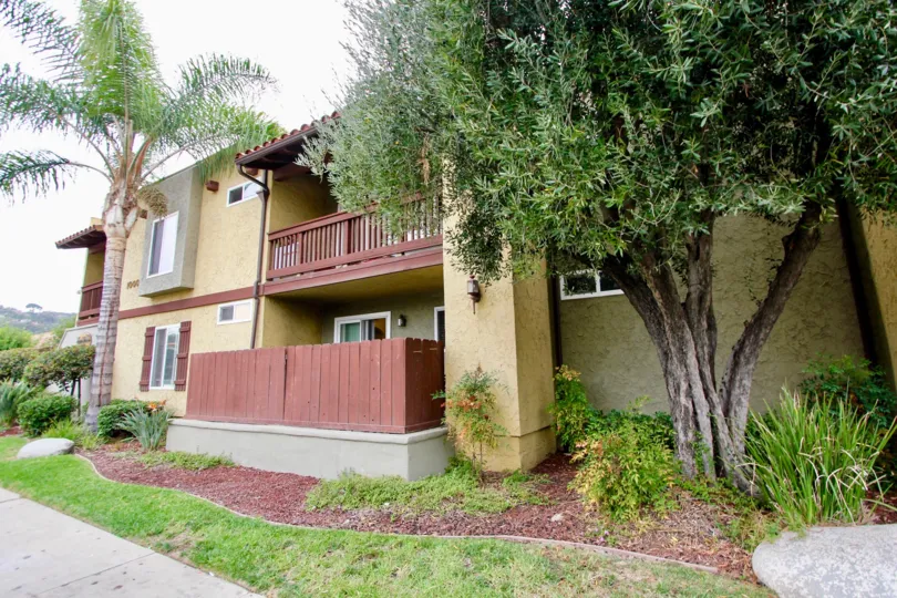 A two story building with maroon porches in the community Paseo Del Sol Villas.