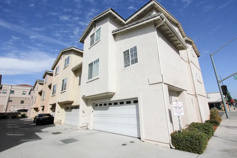 Street view of 2 story houses above garages. Residential.