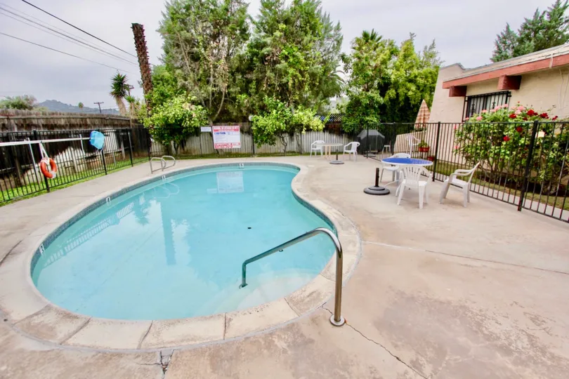 VERY BEAUTIFUL HOUSE. IN FRONT OF IT THERE ARE FOUR SMALL TREES. AND THERE IS A ROAD, VERY CLEAN. AND THERE IS A POOL.