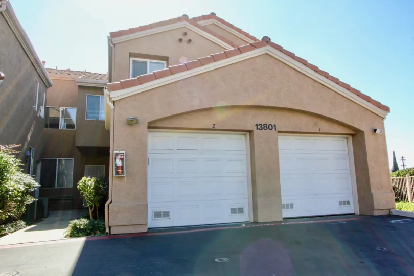 Two white garages attached to residence with driveway at The Knolls in El Cajon CA