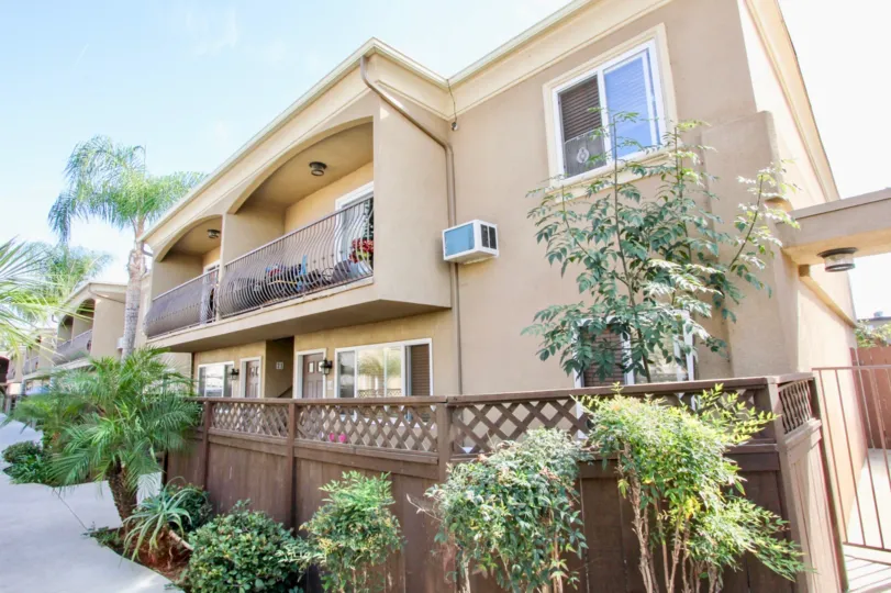 Brown apartment building with lush landscaping in the city of El Cajon