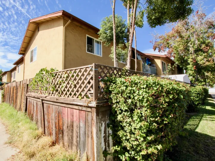 A corner home with fence and vegetation in Verde Villas, California.