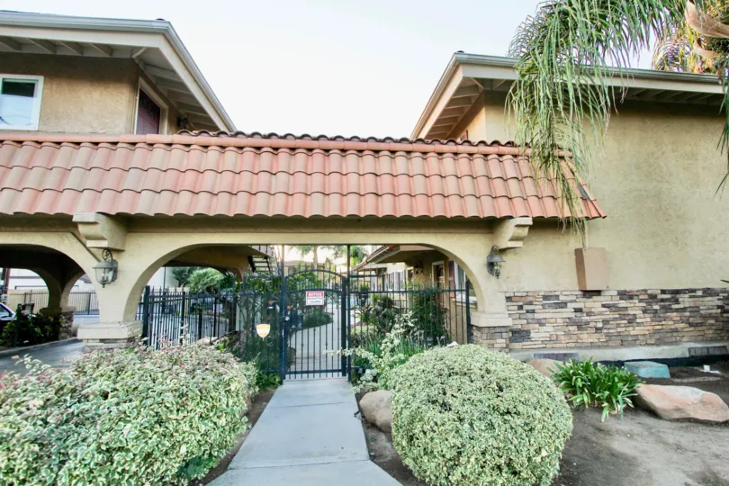 A sunny day in the gated area of Villa Toscano, bushes, gate apartments