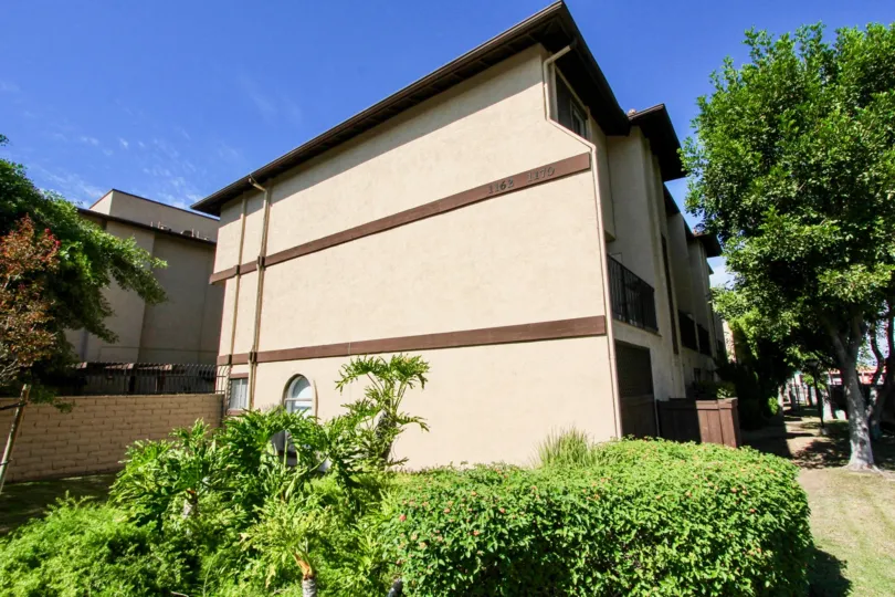 A sunny day in Vintage 81 has villa with bushes and trees