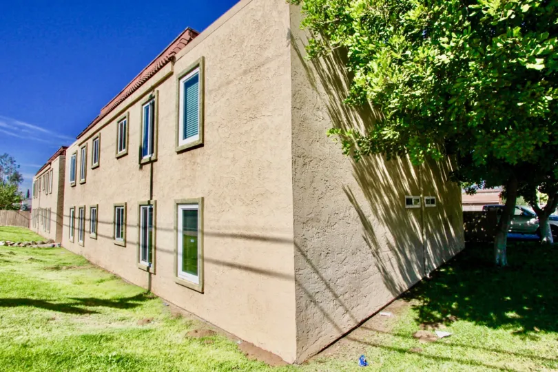 Two story brown condominiums near grass field inside Washington Heights in El Cajon CA