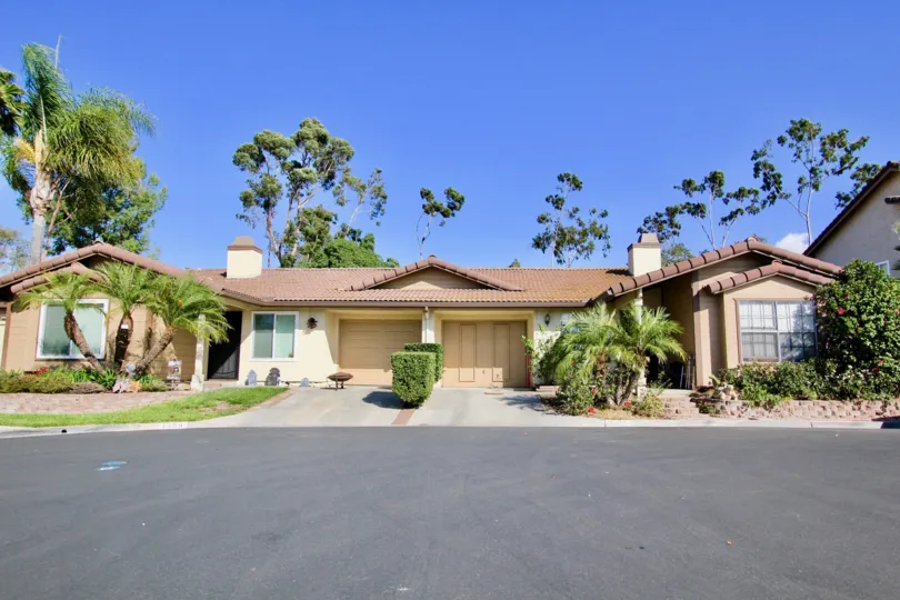 front view of the building with trees plants and road in Avocado Estates