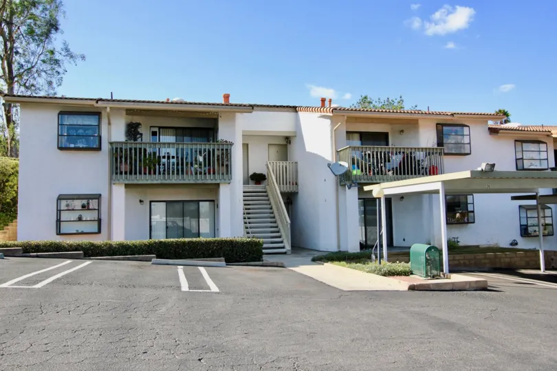 Bernardo Hills Escondido, California White apartment building with two floors. A flight of stairs, two balconies, and several windows are visible.