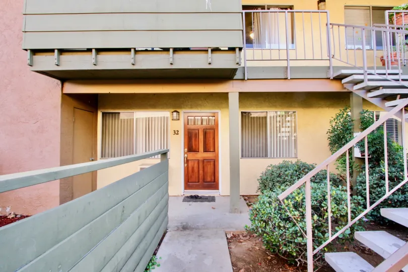 Grand Tree Park community Escondido California shrubbery landscaping wooden door outdoor lighting fence stairs balcony windows vertical shades