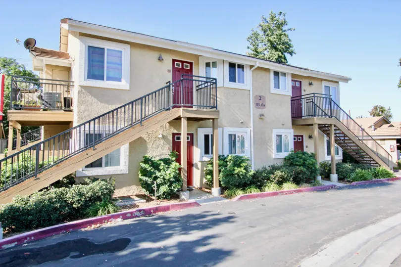 Four similar side-by-side units with identical red doors.