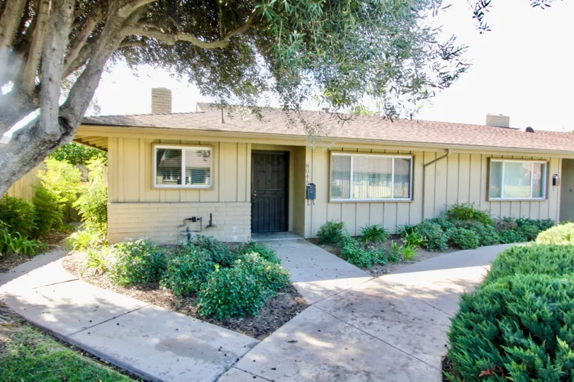 Single story homes with walkways and plants at Holiday Gardens in Escondido California