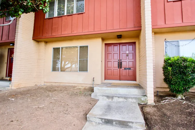 Walkway leading up to giant red doors at Monte Cristo Villas in Escondido California