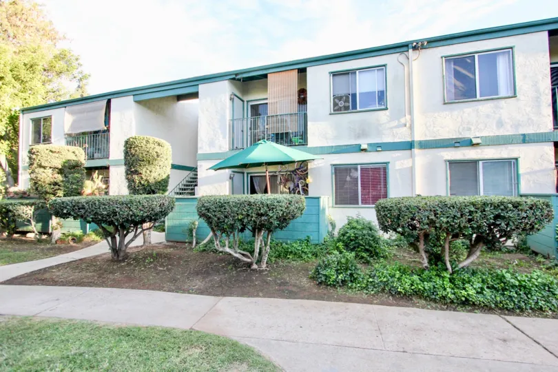 Two-story house with a beach umbrella and decorative trees in Pepperwood Meadows