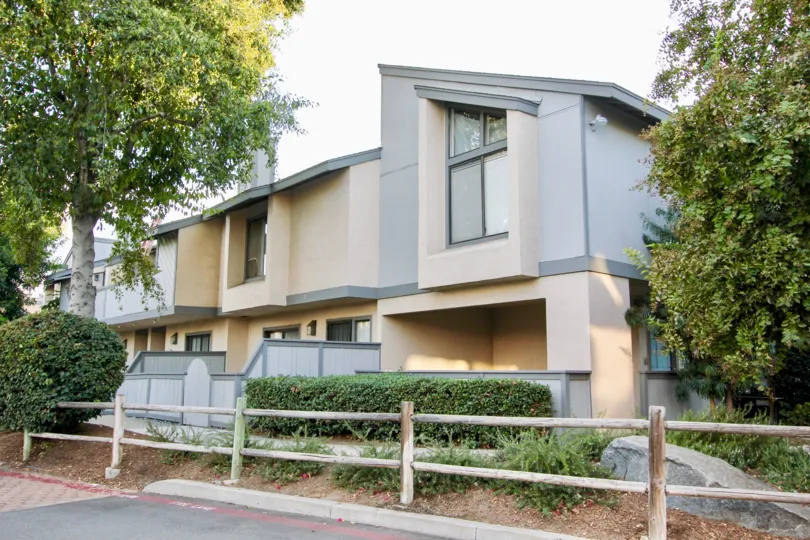 Two story residential units behind a wooden fence at Quarry Glen in Escondido California