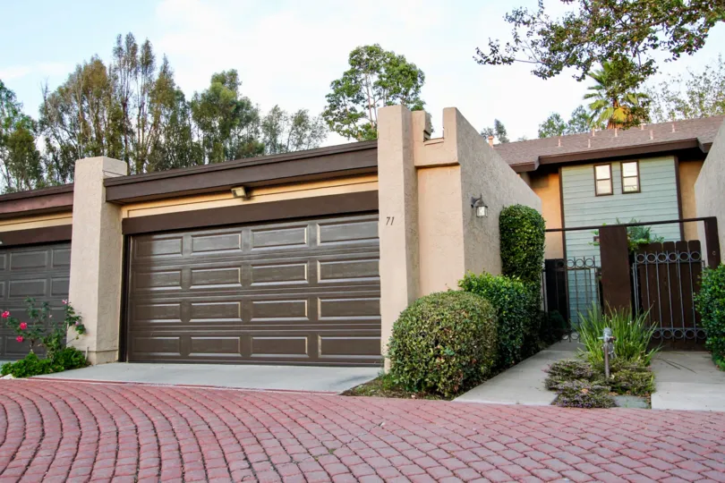 Skylark Terrace in Escondido California luxury stucco apartments with garage and gated coartyard shrubs and trees and tiled driveway