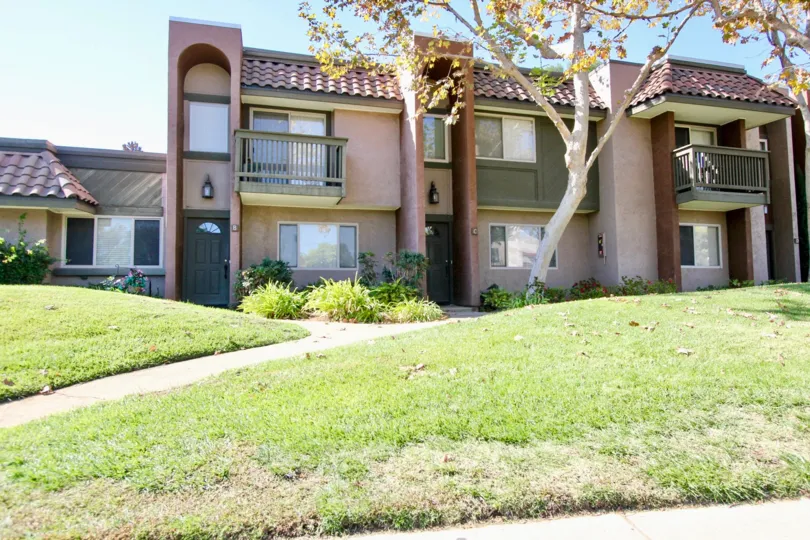Two-story condos with balconies, sidewalks and lawn, located in Sommerset Woods, Escondido, California.