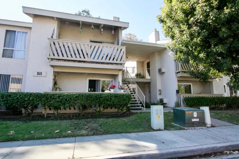 Balcony decorated with the plants and flower and flag in front side and Plants and trees in front of the building in Sun Mountain Springs