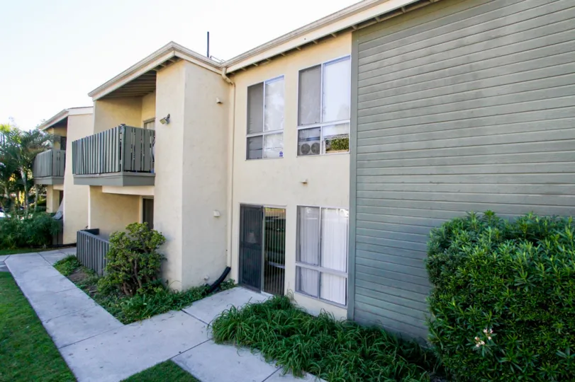 A house with a balcony and a gray wall in Village Green neighborhood