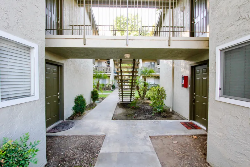 Walkway near residential buildings with attached stairway at White Oak Estates in Escondido California
