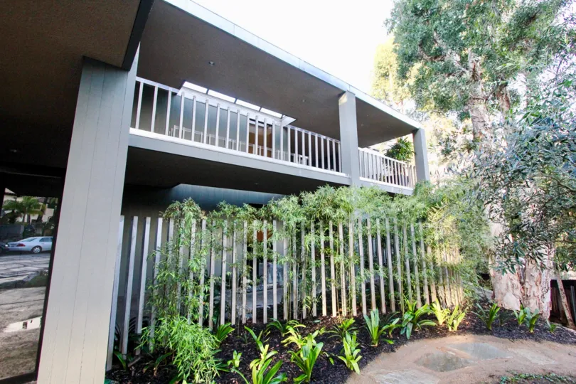 A two-storey townhomes with climbing vines and modern railings in 3100 Front neighborhood.