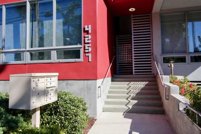entrance view with the main door in middle and post box on right and the building is colored red