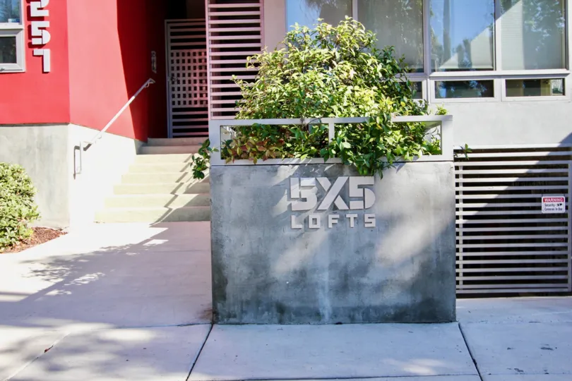 Red color Building in 5x5 Lofts has number 257 under with grow bushes