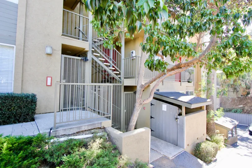 A sunny day in the area of 727 Robinson, outside, stairs, trees, bushes, condos
