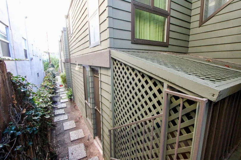 THE HOUSE IN THE 7TH AVENUE CONDOS WITH THE PLANTS, WOODEN DOOR, WINDOWS