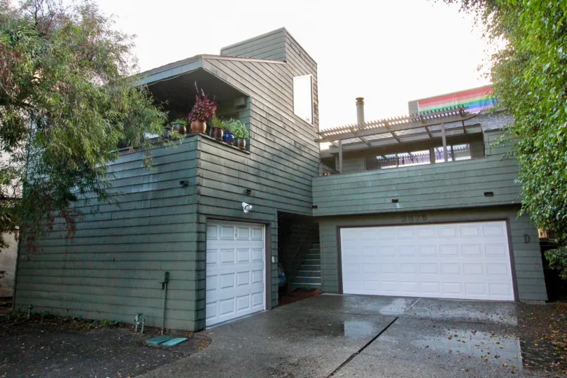 Garage doors at the 7th Avenue Condos with trees on both sides of the driveway
