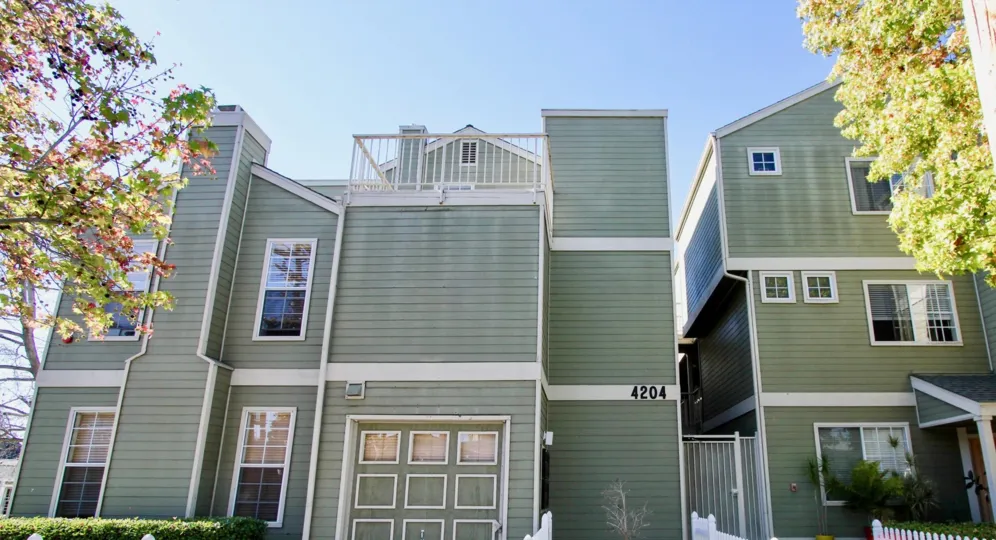 Arbor Village gray-green buildings with garage and gated entry Hillcrest California