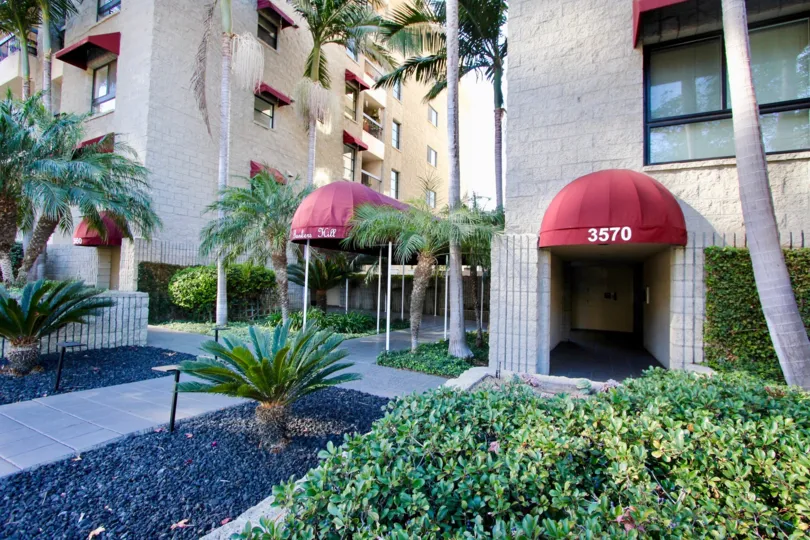 Roof Coverage has number 3570 and bushes, trees in opposite to the Apartment in Bankers Hill Towers